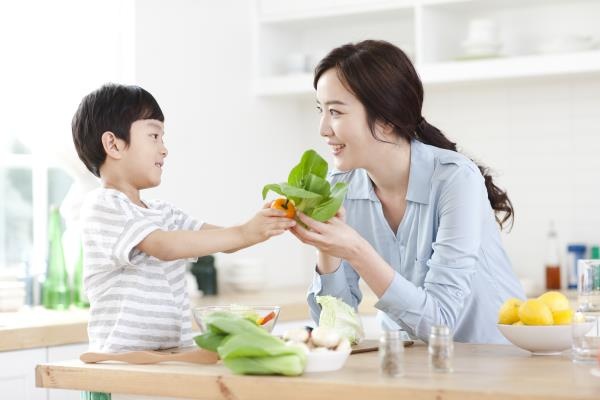 엄마와 아들이 식재료를 들고 환하게 웃고 있다